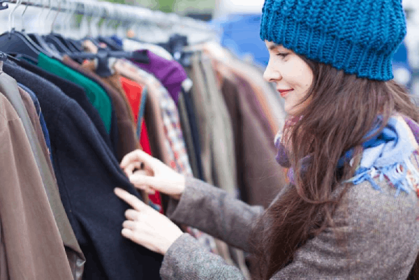 buyer looking at clothes in a thrift shop - buisness plan thrift shop